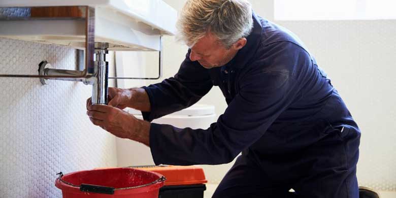 Engineer carrying out emergency plumbing